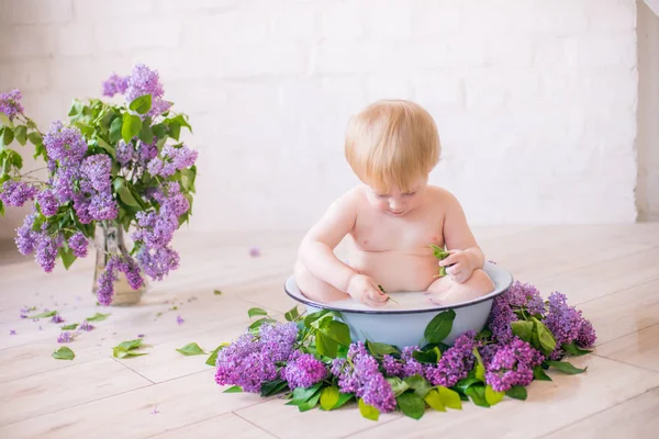 Leylak çiçekleri ile antika süt banyosunda bebek çocuk yakın