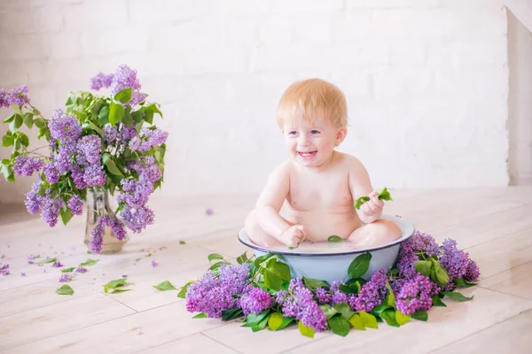 Leylak çiçekleri ile antika süt banyosunda bebek çocuk yakın