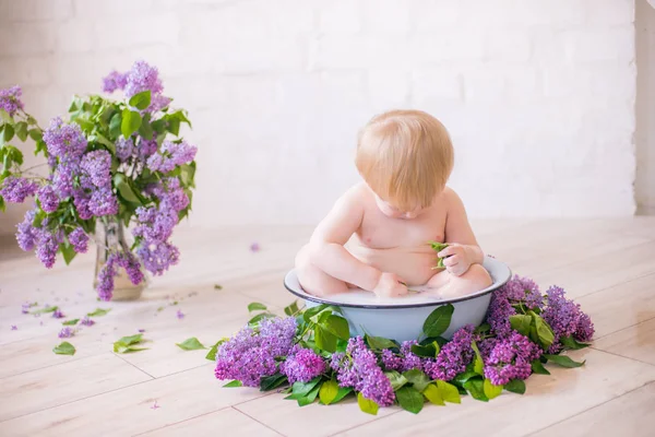 Leylak çiçekleri ile antika süt banyosunda bebek çocuk yakın