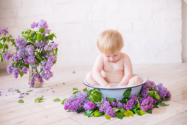 Leylak çiçekleri ile antika süt banyosunda bebek çocuk yakın