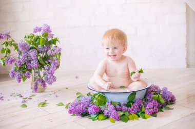 Leylak çiçekleri ile antika süt banyosunda bebek çocuk yakın