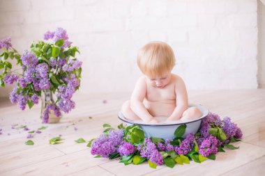 Leylak çiçekleri ile antika süt banyosunda bebek çocuk yakın