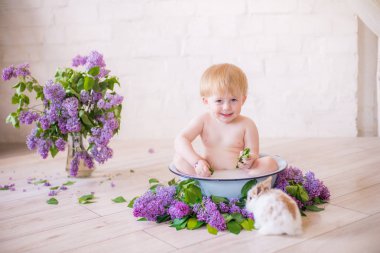 Leylak çiçekleri ile antika süt banyosunda bebek çocuk yakın