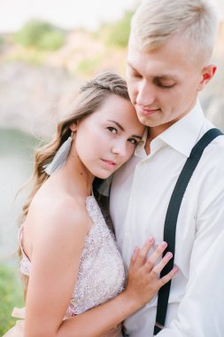 Nehir ya da göl kenarında zarif kibar bir gelin ve damat. Aşık düğün çifti 