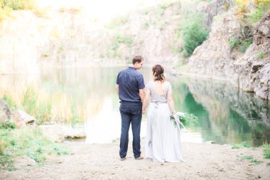 Nehir ya da göl kenarında zarif kibar bir gelin ve damat. Aşık düğün çifti 