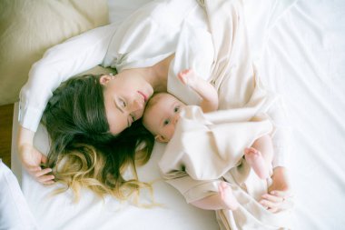 Mutlu bir aile. Anne yatak odasında bebeğiyle oynuyor.