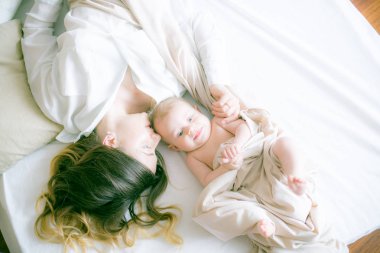 Mutlu bir aile. Anne yatak odasında bebeğiyle oynuyor.