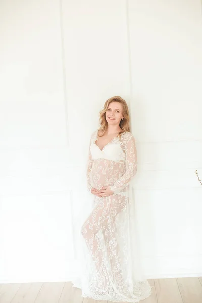 妊娠中の女性の若い美しい妊婦ベリー かわいい妊娠中の腹 白いレースのペイニョワールで美しい妊娠中の女性ブロンド 白いランジェリーの女の子 — ストック写真