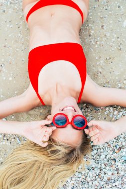 Kırmızı bir mayo uzun saçlı güzel bir genç kız güneşli sıcak gün denizde Sahilde dinlenmek