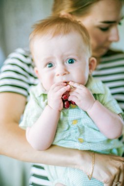 Yaz evde el ve anne kiraz ile sevimli küçük bebek