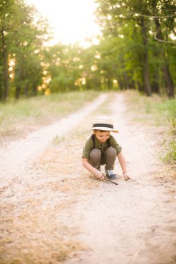 Yaz aylarında parkta bir hasır şapkalı küçük çocuk gün batımı