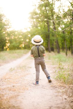 Bir şapkalı küçük çocuk ve yaz aylarında parkta annesi gün batımı