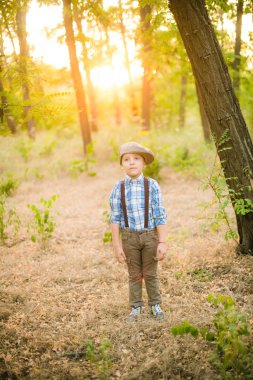 Yaz aylarında parkta bir şapkalı küçük çocuk gün batımı