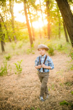 Yaz aylarında parkta bir şapkalı küçük çocuk gün batımı