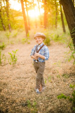 Yaz aylarında parkta bir şapkalı küçük çocuk gün batımı