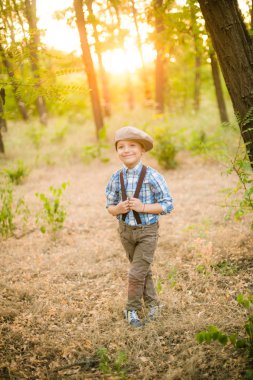 Yaz aylarında parkta bir şapkalı küçük çocuk gün batımı