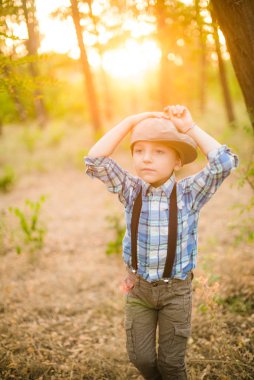 Yaz aylarında parkta bir şapkalı küçük çocuk gün batımı