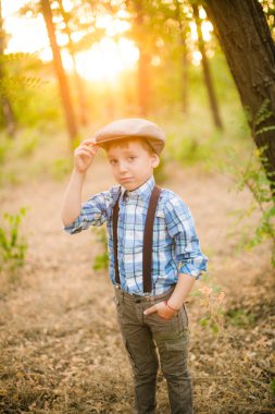 Yaz aylarında parkta bir şapkalı küçük çocuk gün batımı