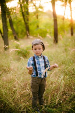 Yaz aylarında parkta bir şapkalı küçük çocuk gün batımı