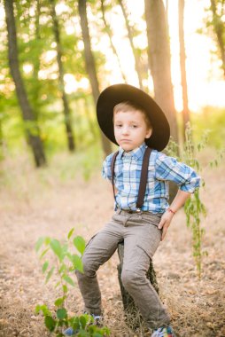 Yaz aylarında parkta bir şapkalı küçük çocuk gün batımı