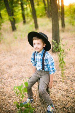 Yaz aylarında parkta bir şapkalı küçük çocuk gün batımı