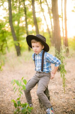 Yaz aylarında parkta bir şapkalı küçük çocuk gün batımı