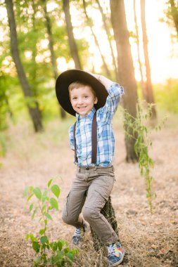 Yaz aylarında parkta bir şapkalı küçük çocuk gün batımı