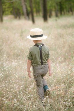 Yaz aylarında parkta bir hasır şapkalı küçük çocuk gün batımı