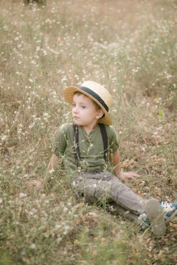 Yaz aylarında parkta bir hasır şapkalı küçük çocuk gün batımı
