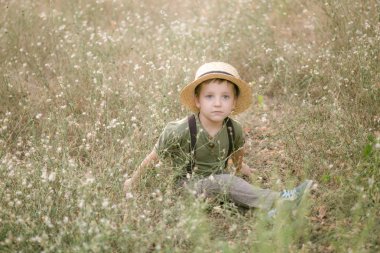Yaz aylarında parkta bir hasır şapkalı küçük çocuk gün batımı