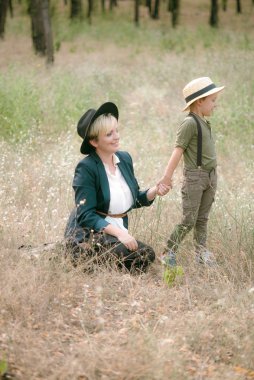 Bir şapkalı küçük çocuk ve yaz aylarında parkta annesi gün batımı