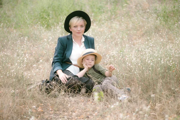 Bir şapkalı küçük çocuk ve yaz aylarında parkta annesi gün batımı