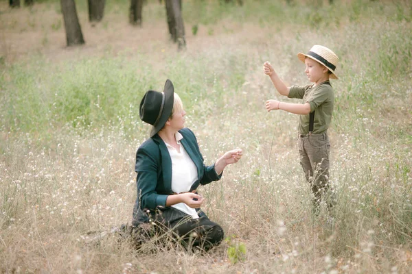 帽子をかぶった小さな男の子と日没の夏の公園で彼のお母さん — ストック写真