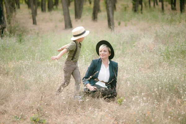 帽子をかぶった小さな男の子と日没の夏の公園で彼のお母さん — ストック写真