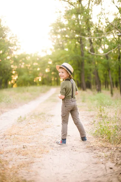 日没の夏に公園で麦わら帽子をかぶった小さな男の子 — ストック写真