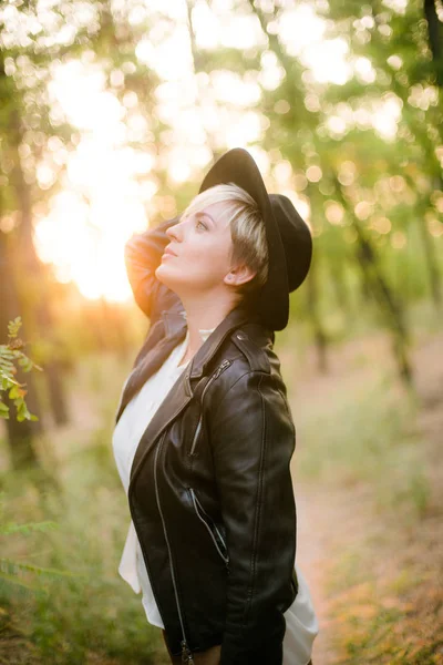 夏天日落时分 在公园的公园里 穿着黑色帽子和皮夹克的女孩 — 图库照片