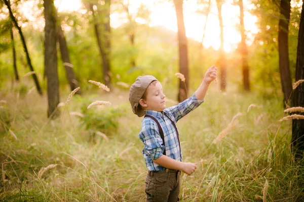 夏天日落时分在公园里戴帽子的小男孩 — 图库照片