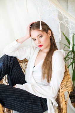 Trend makyaj ve uzun saçlı bir hamak yanında bir hasır hasır sandalye dinlenme ile çekici kız modeli