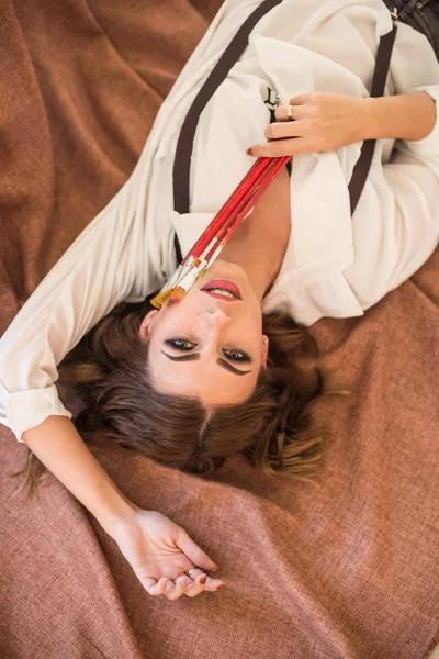 Attractive Girl Artist Dark Hair Brushes Hand Lies Floor Studio — Stock Photo, Image