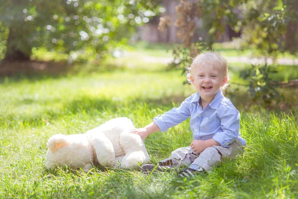 Bambino Con Capelli Biondi Che Gioca Con Orsacchiotto Nell Erba — Foto Stock