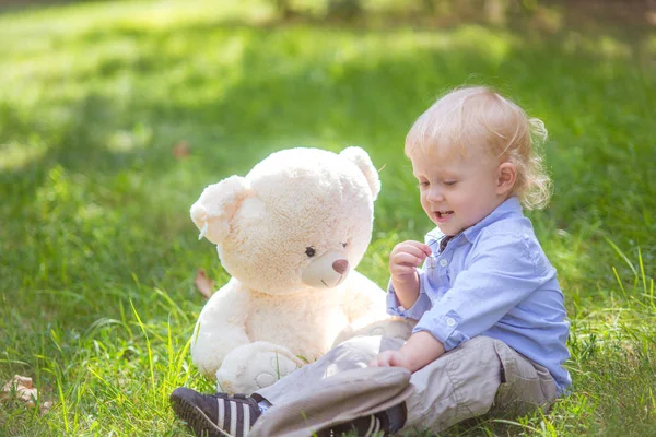 Menino Com Cabelo Loiro Brincando Com Ursinho Pelúcia Grama Verde — Fotografia de Stock