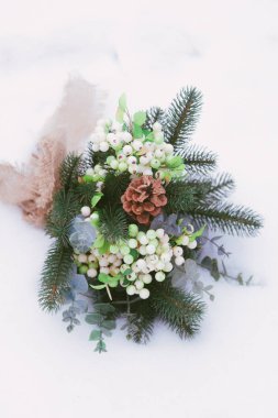 parkta kar üzerinde çam iğneleri ve konileri ile kış düğün buketi