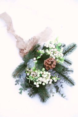 parkta kar üzerinde çam iğneleri ve konileri ile kış düğün buketi