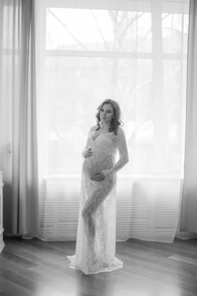 妊娠中の女性の若い美しい妊婦ベリー かわいい妊娠中の腹 白いレースのペイニョワールで美しい妊娠中の女性ブロンド 白いランジェリーの女の子 — ストック写真