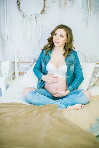 Piękna Kobieta Ciąży Niebieskie Dżinsy Jest Łóżku Koncepcja Szczęśliwego Macierzyństwa — Zdjęcie stockowe