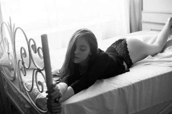 ベッドに横になっているランジェリーで長い黒髪の魅力的なセクシーな女性の肖像画 — ストック写真