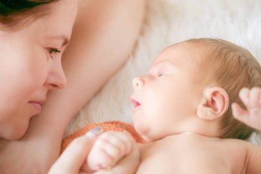 Yatakta anne ile yeni doğmuş bir bebeğin ev portresi