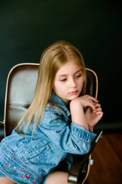 Kot elbise Studio siyah bir zemin üzerine sarı saçlı güzel şık küçük kızla