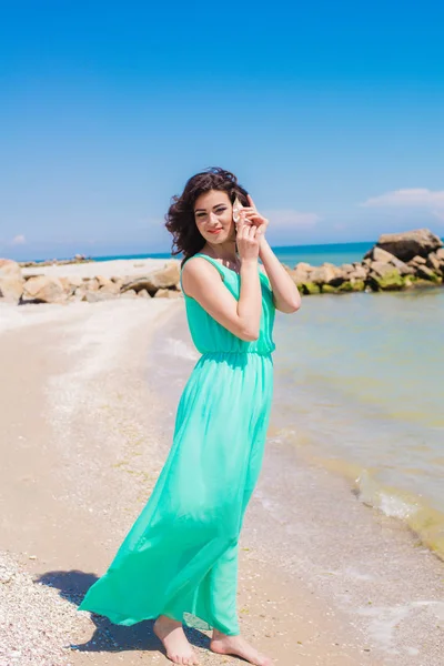 Young girl on summer beach with shell — Stock Photo, Image