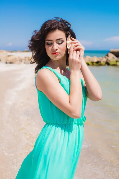 Young girl on summer beach with shell — Stock Photo, Image